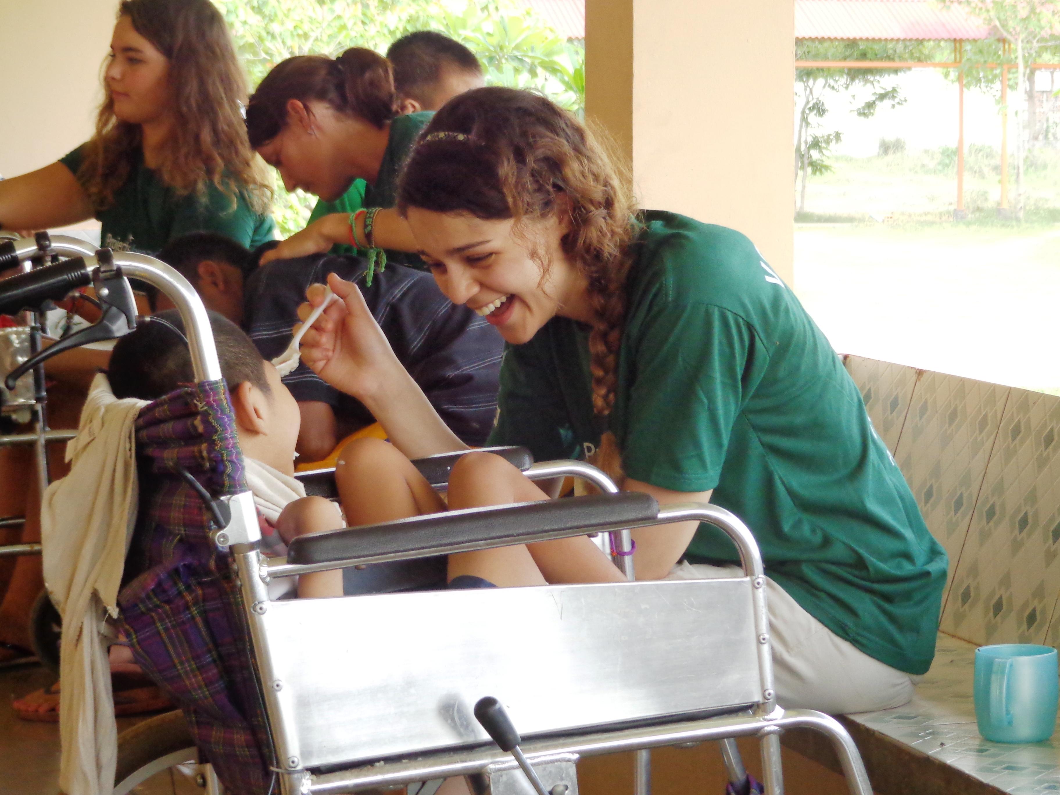 A female Projects Abroad intern helping feed a child as she is on her occupational therapy internship in Cambodia. A female Projects Abroad intern is seen helping a child eat as part of her occupational therapy internship in Cambodia.